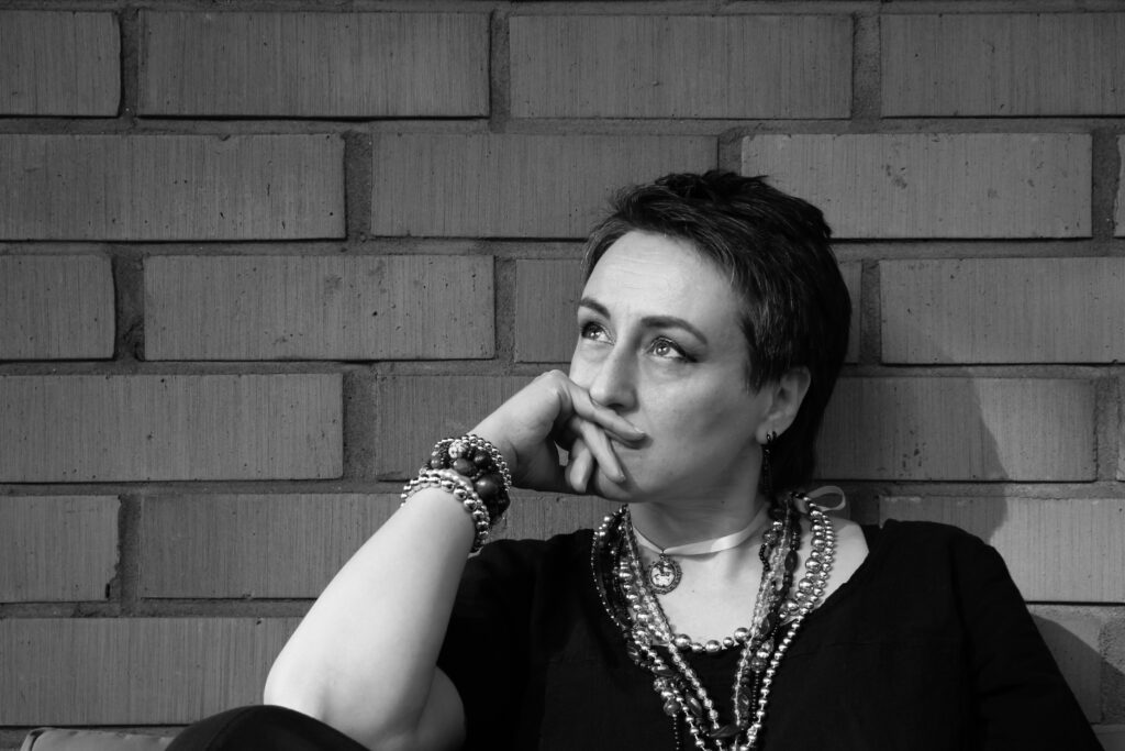 Mustavalkoinen kuva pohtivaisen oloisesta kirjailijasta.