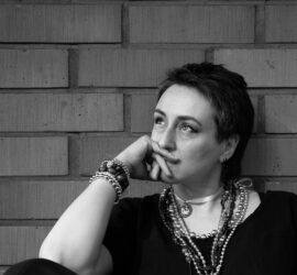 Mustavalkoinen kuva pohtivaisen oloisesta kirjailijasta.