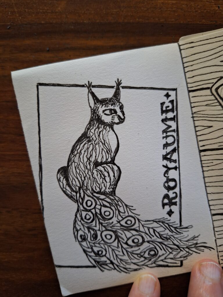 Tussipiirros eläimestä, joka on osaksi kissa ja osaksi riikinkukko. Vieressä lukee "Royaume".